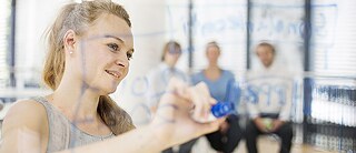 Eine Frau schreibt mit einem Stift auf eine Glaswand. © Foto: Goethe-Institut/Loredana La Rocca Goethe-Institut Aufgaben und Ziele